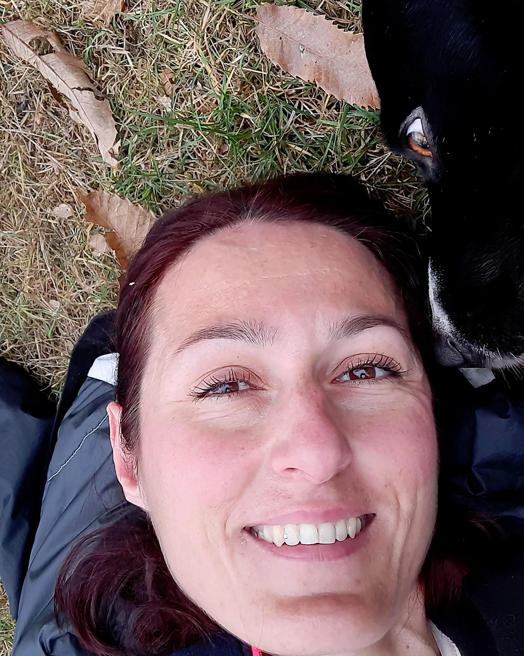 Alessia Villa sorride, sdraiata tra le foglie d’autunno accanto al suo cane